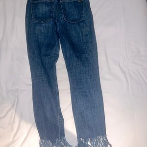Mud-rise blue jeans with fringe bottoms